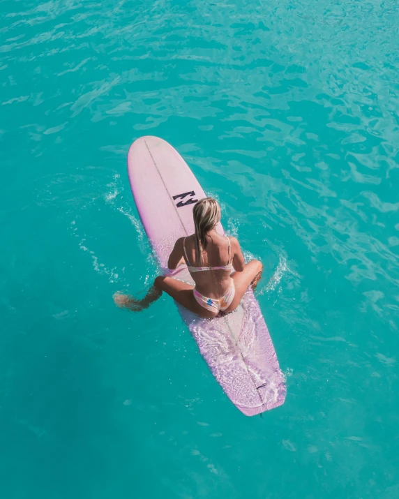 a woman on a pink surf board out in the water