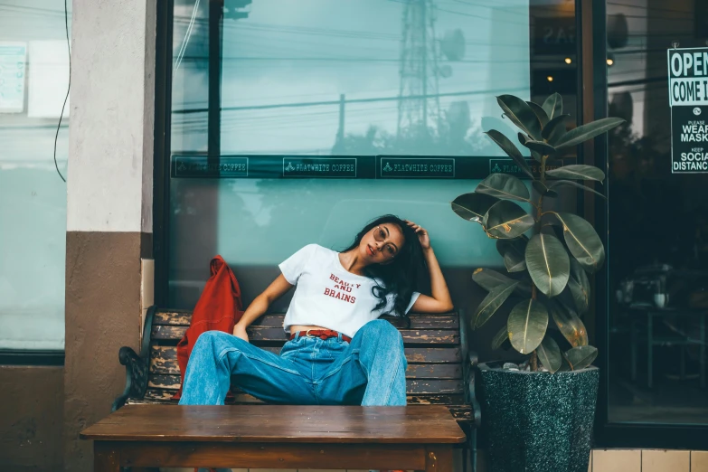 woman sitting on a bench in front of a building