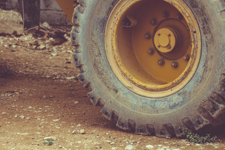 the back end of a yellow tractor wheel