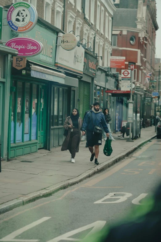 a man and woman walking along side a sidewalk