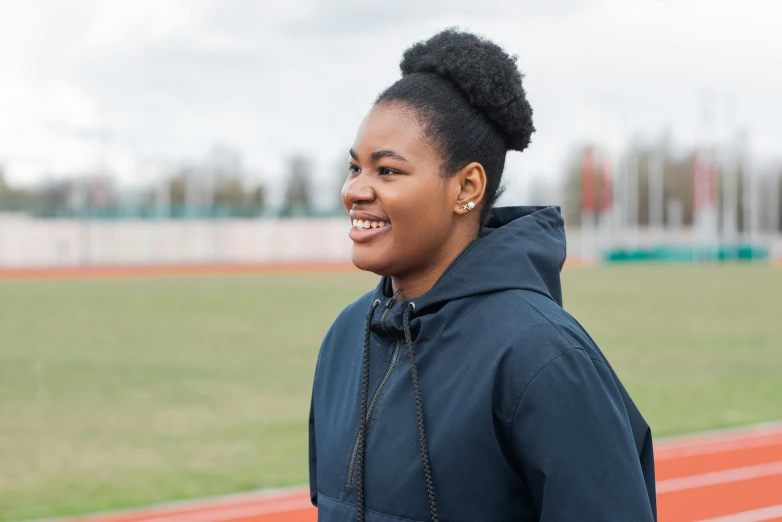 a woman in a blue sweatshirt is smiling