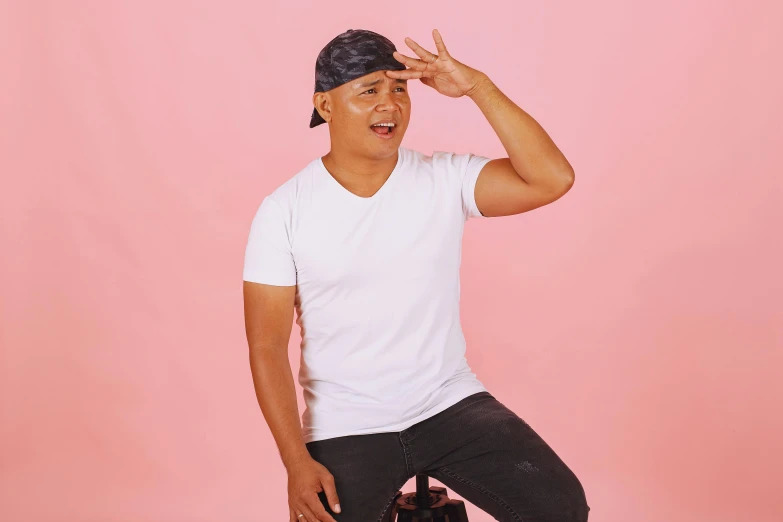 a man is posing for a picture wearing a white shirt and black cap