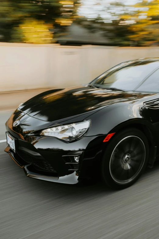 black car in motion on roadway in urban area