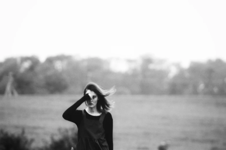 a black and white po of a woman holding her hair