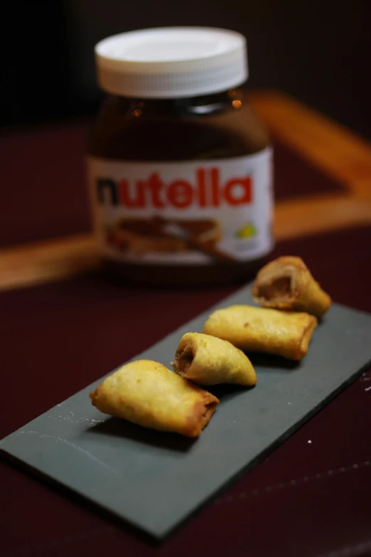 food item on plate displayed on table next to jar of nutella