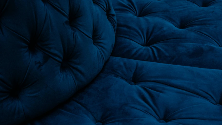 an upholstered bed with deep blue fabric