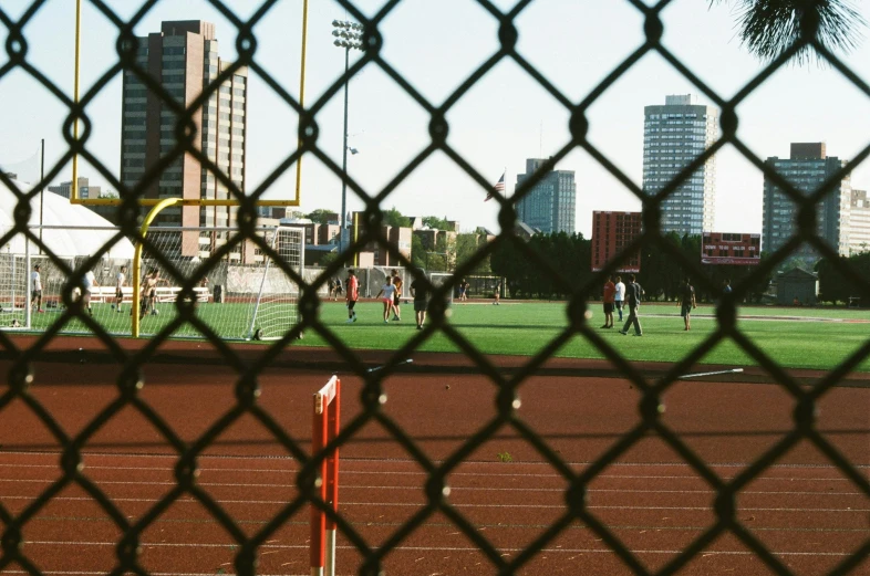 baseball field with trees and buildings in background