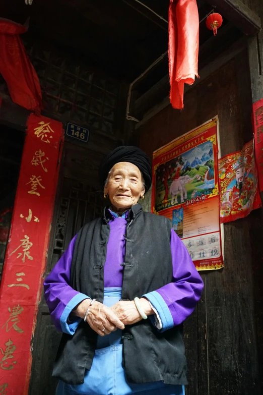 a woman standing in front of hanging red and pink decorations