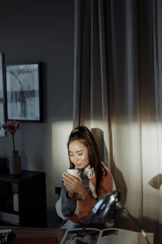 a woman sitting at her desk with an open book