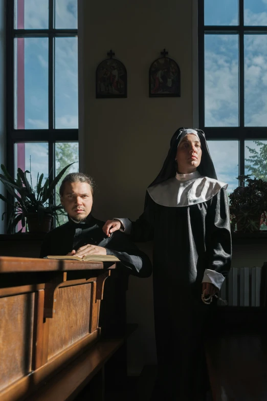 two people are shown in nun costumes standing behind a table