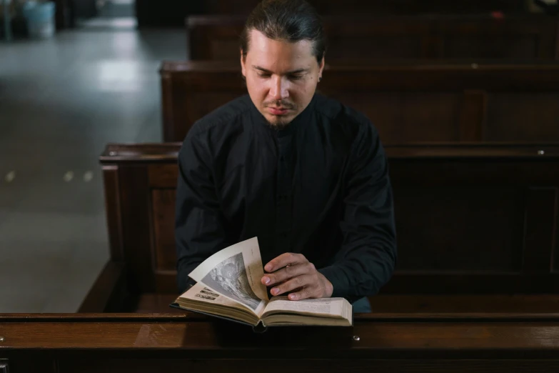 a man reading a book while sitting at a table