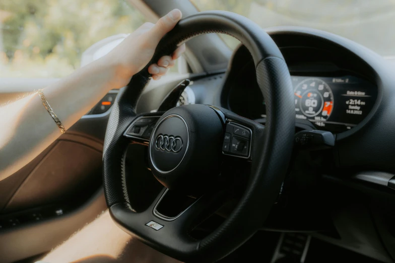 an audi steering wheel on a vehicle that has its hand on the dashboard