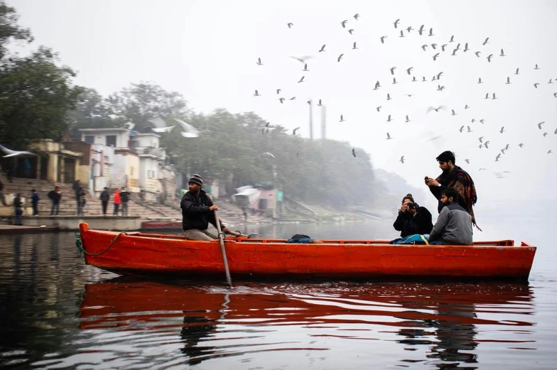 several people sitting on a small boat in the water