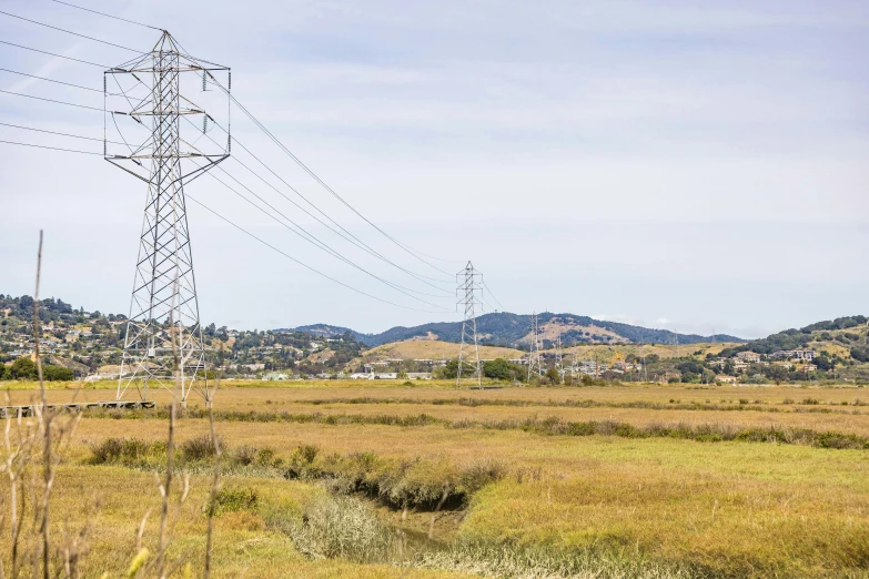 an electric power tower in a grassy field