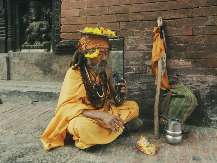 an old indian man with headdress and flowers sitting next to him