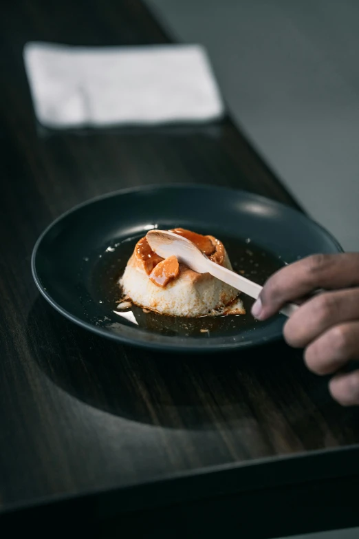 a person eating a small food dish with a spoon