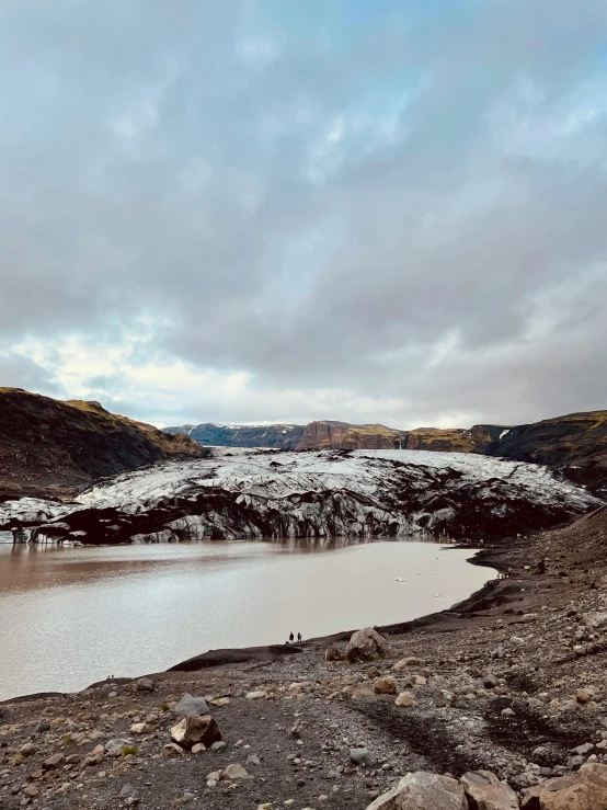 a lake on the side of a mountain with snow