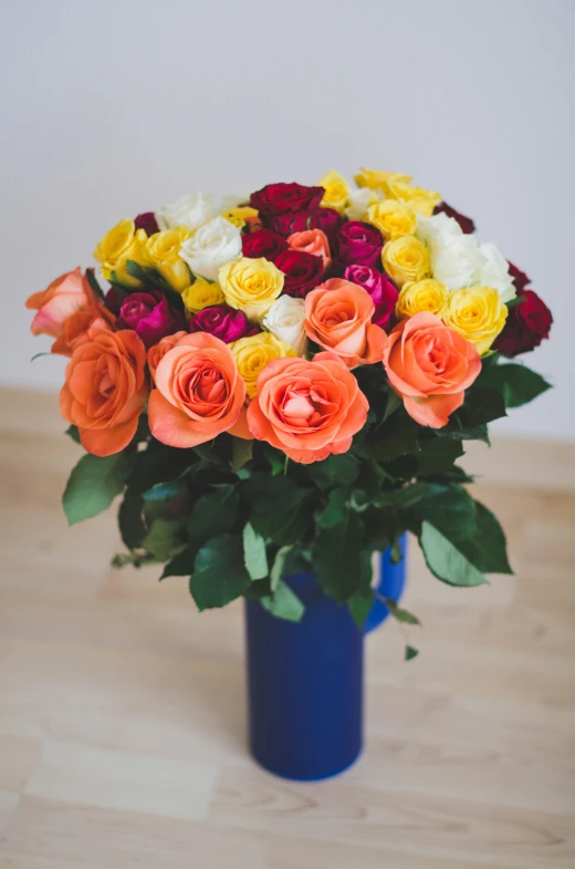 a bouquet of brightly colored flowers in a blue vase