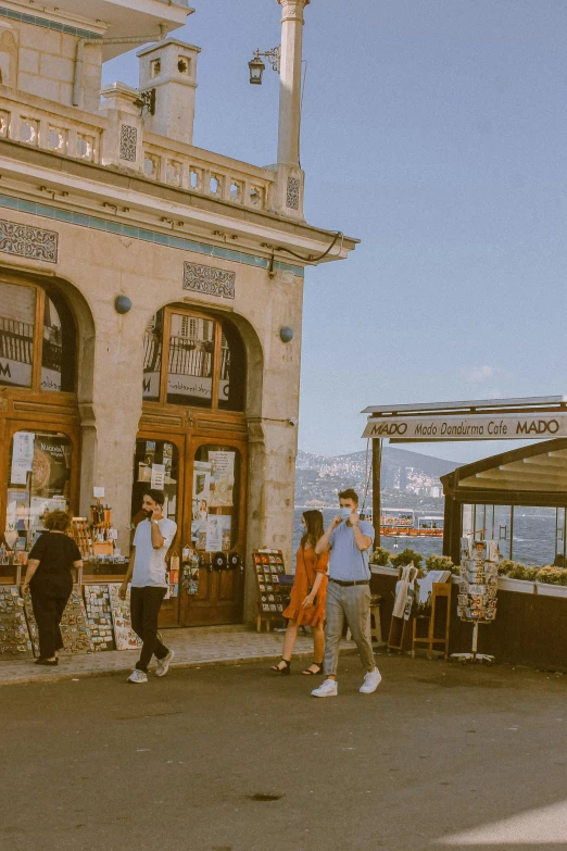 people stand around a farmers market looking at their goods