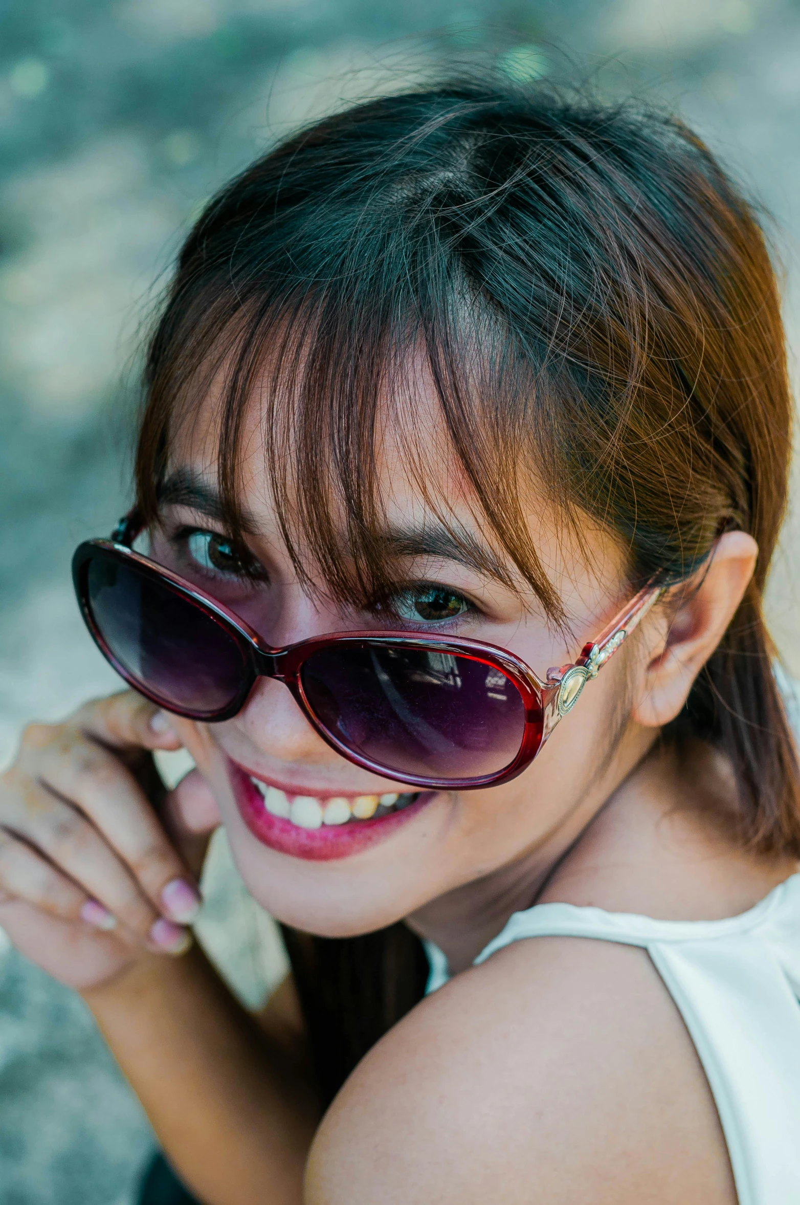 woman with dark sunglasses smiling at camera