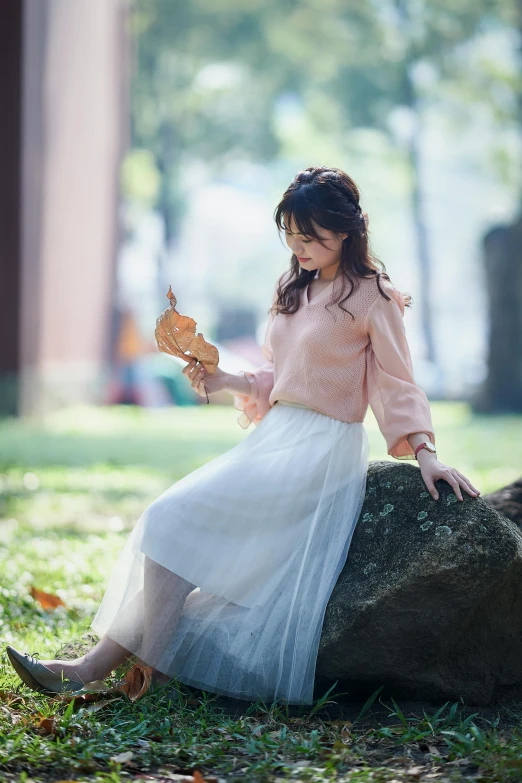 the girl is sitting on the rock with a cookie