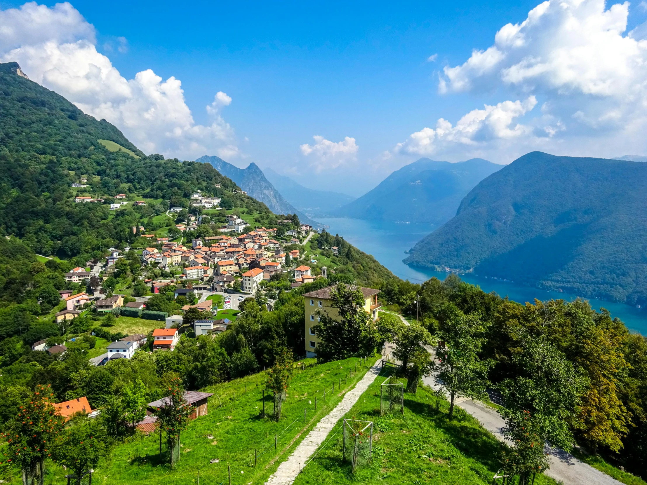 the view over a green valley with a village in the background