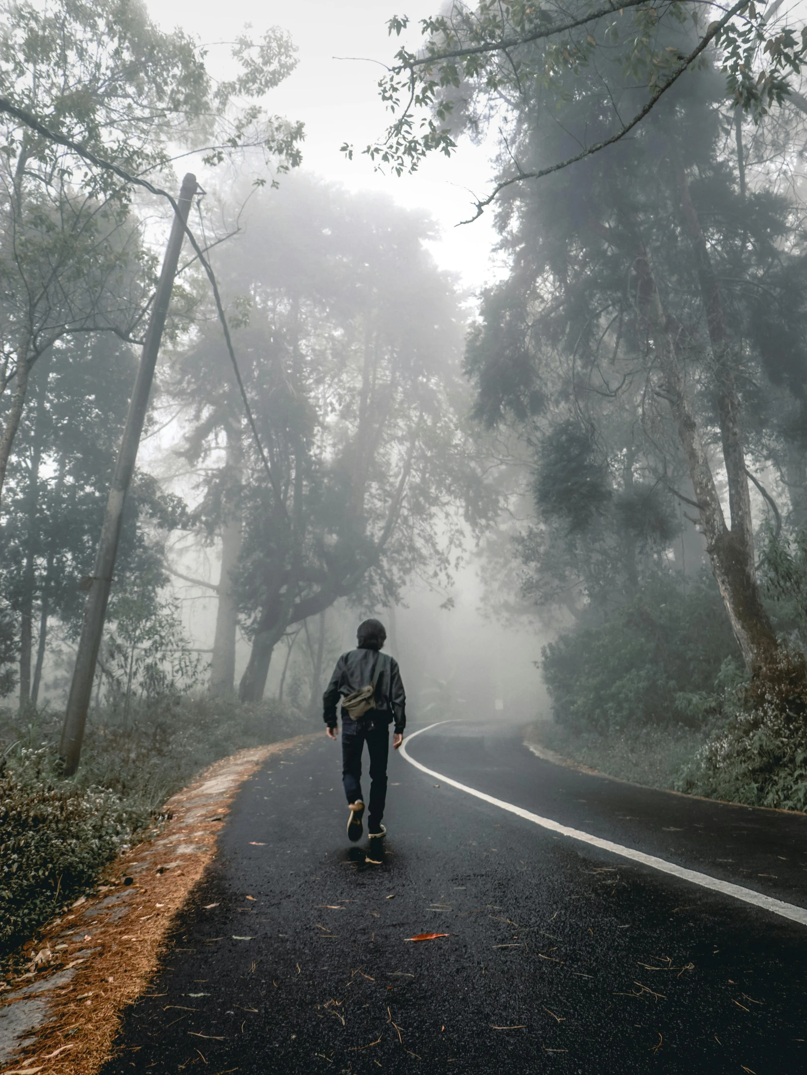 a man riding his skateboard on the street in the fog