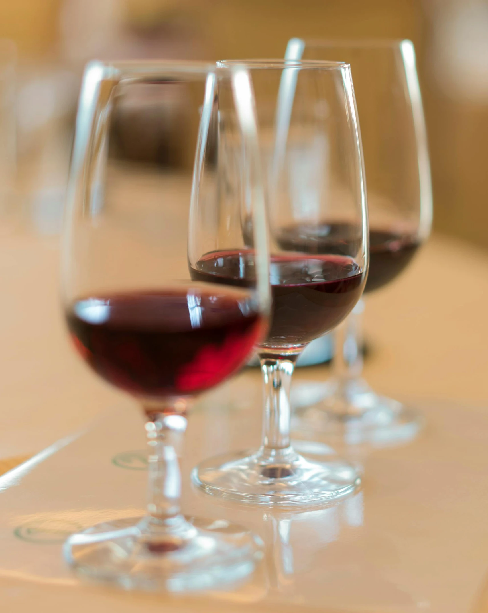 three glasses of wine are lined up on the table