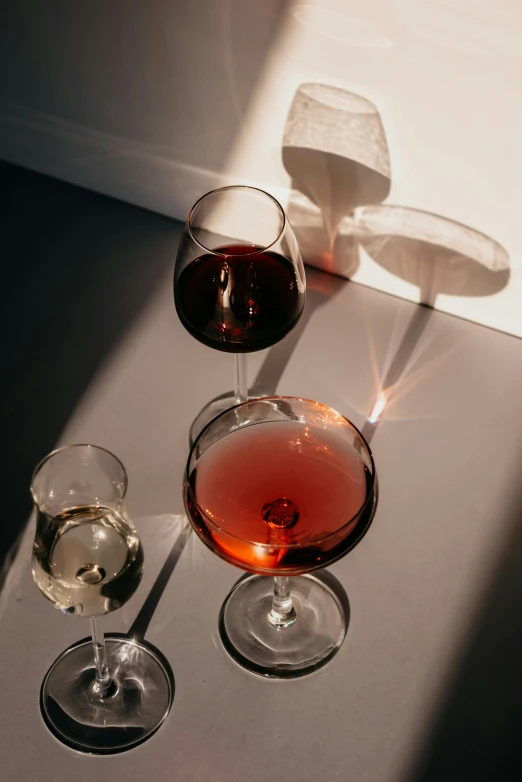 two wine glasses and a beverage are seen on a table
