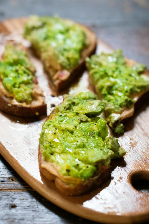 four pieces of bread with green salsa and toast