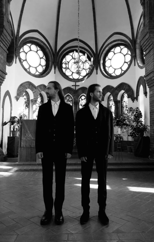 two men in front of a stained glass window