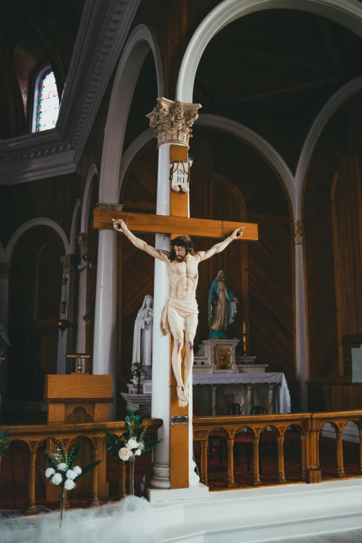 a statue of jesus on top of a wooden cross