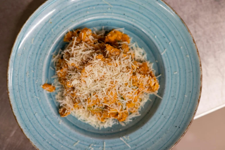 a blue plate with cheese and other food items