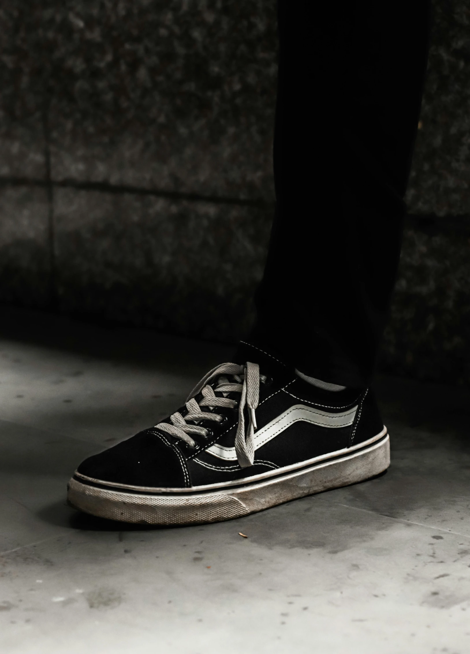 a person wearing black and white shoes is walking along