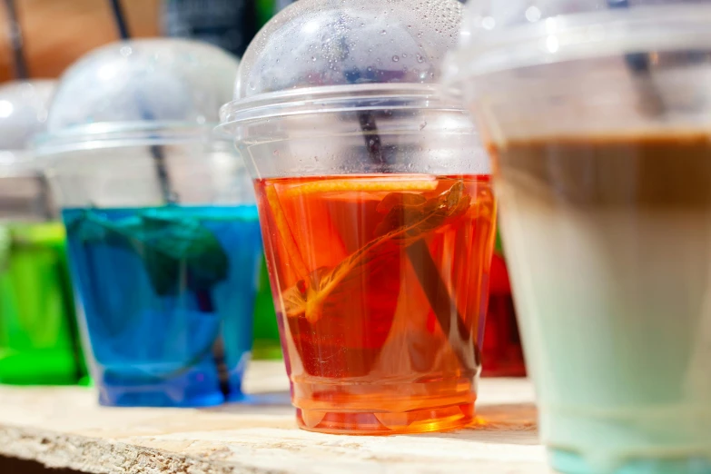 a table with several different colored drinks in cups