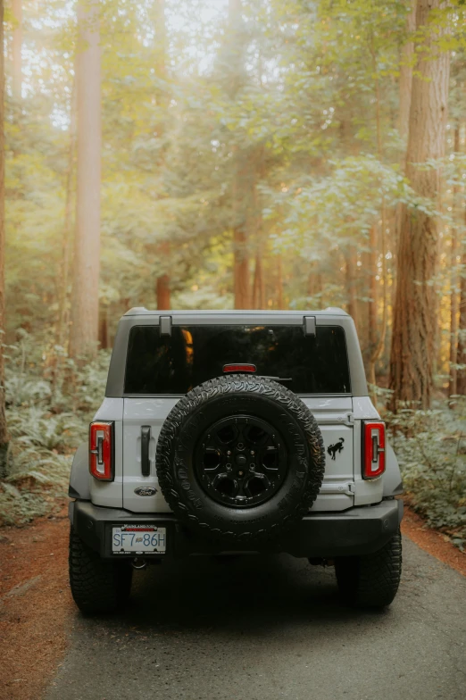 a white jeep with the top tire off on the road