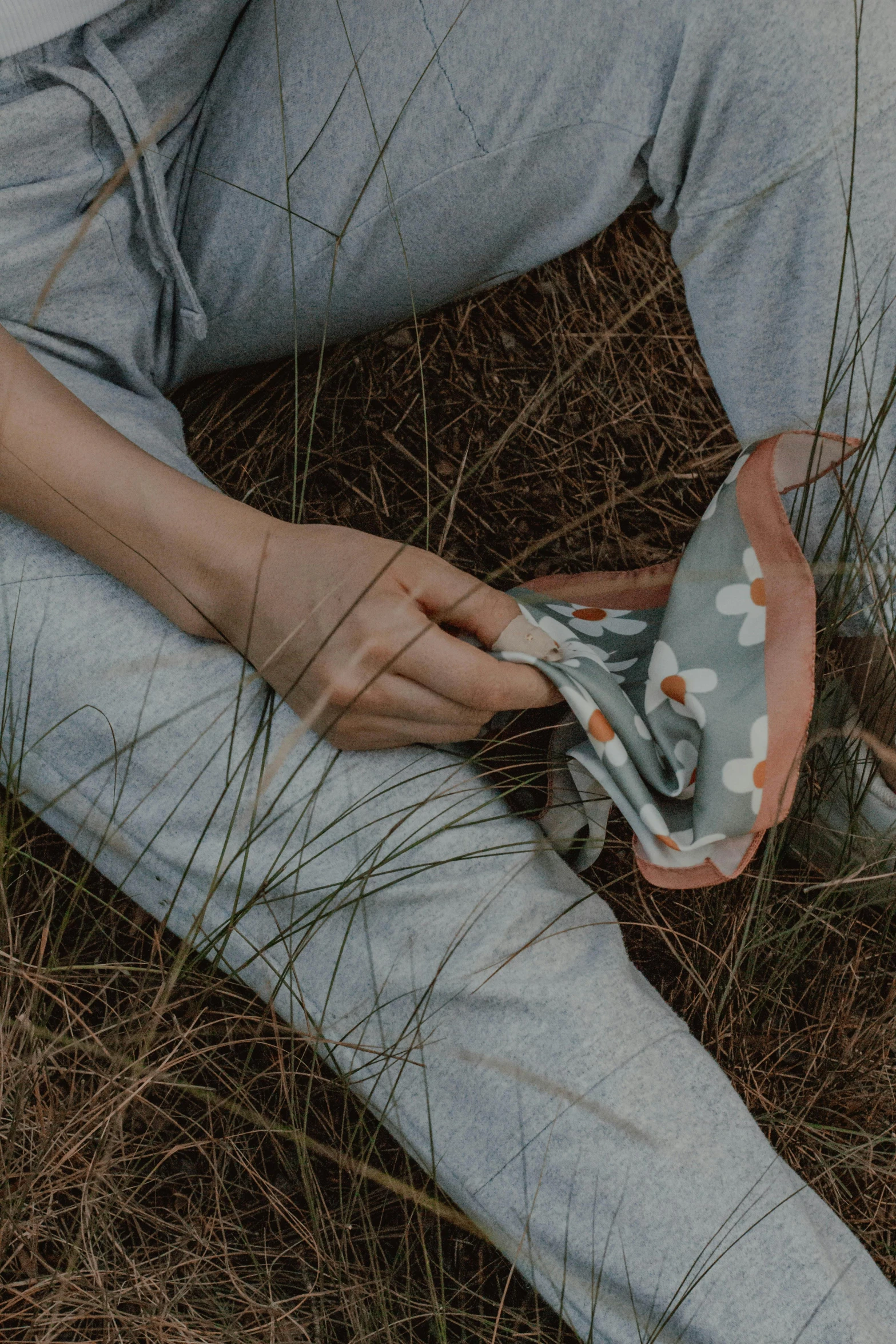 the person is laying in the grass and holding soing