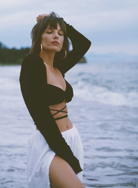 a woman is standing in the water in a bikini