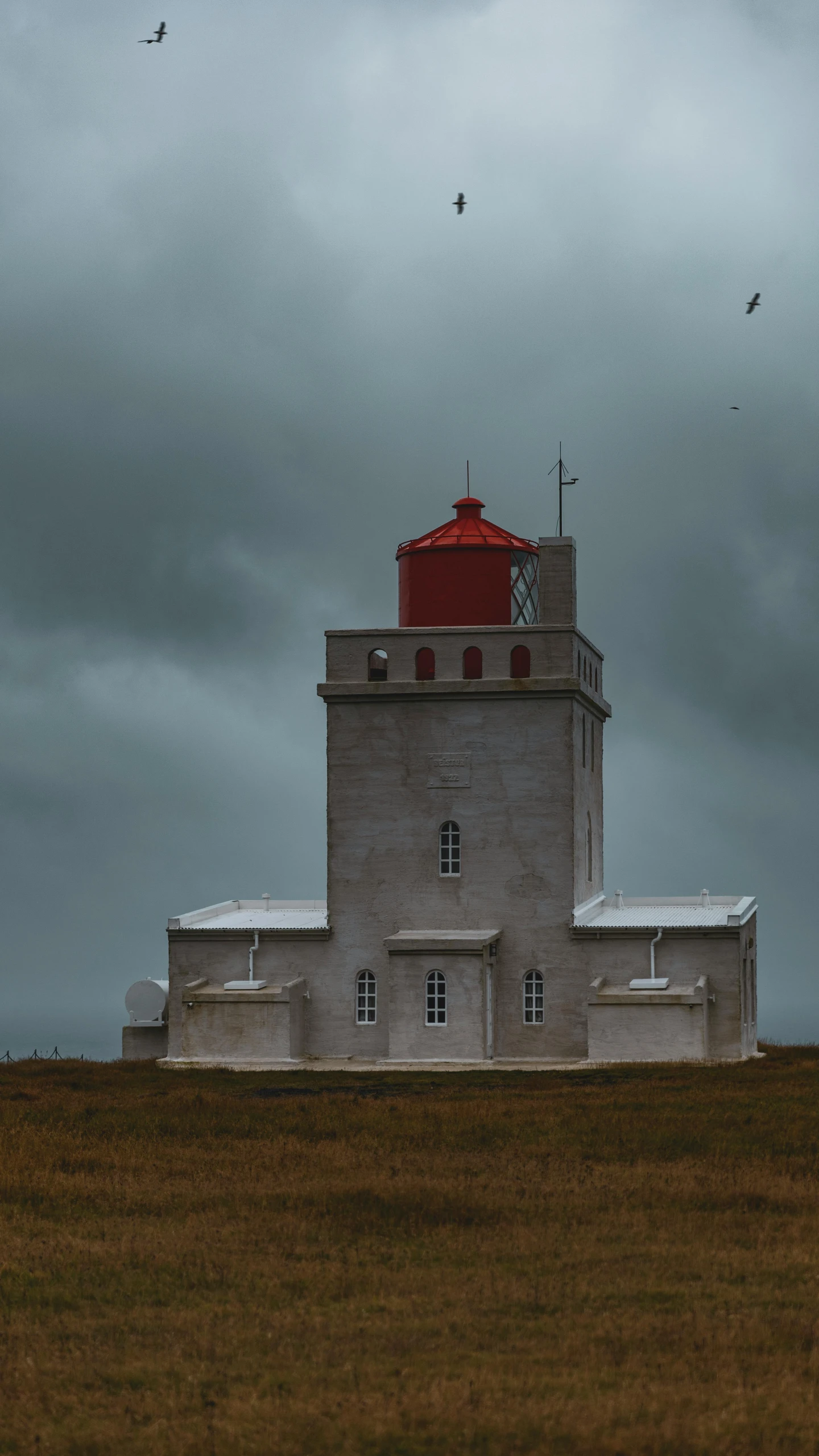 a white lighthouse building on the side of the road