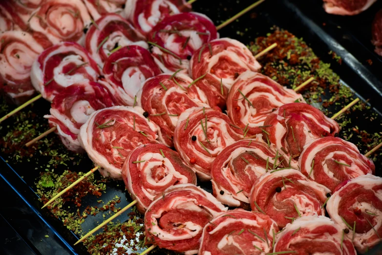slices of meat sit on a grill with herbs