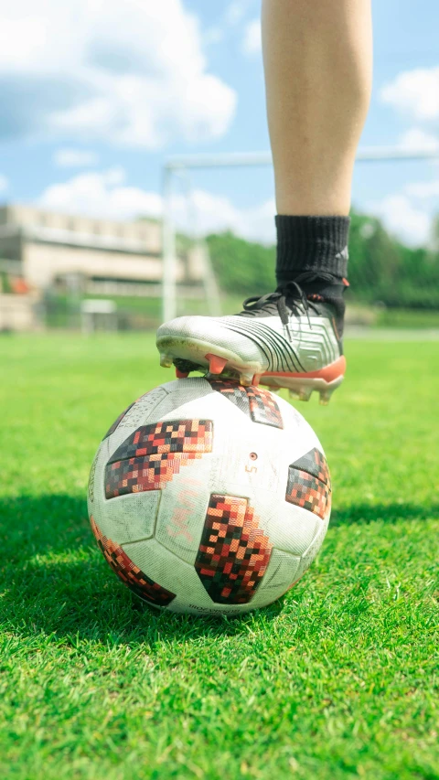 a person with black socks standing on top of a soccer ball