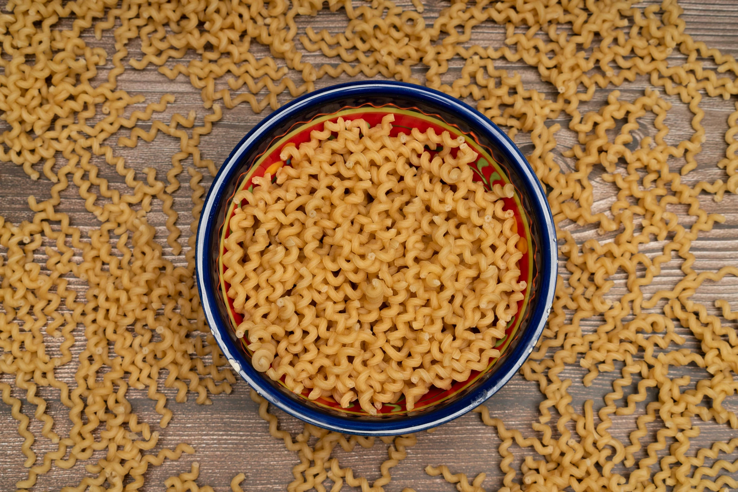 a blue bowl filled with macaroni and cheese