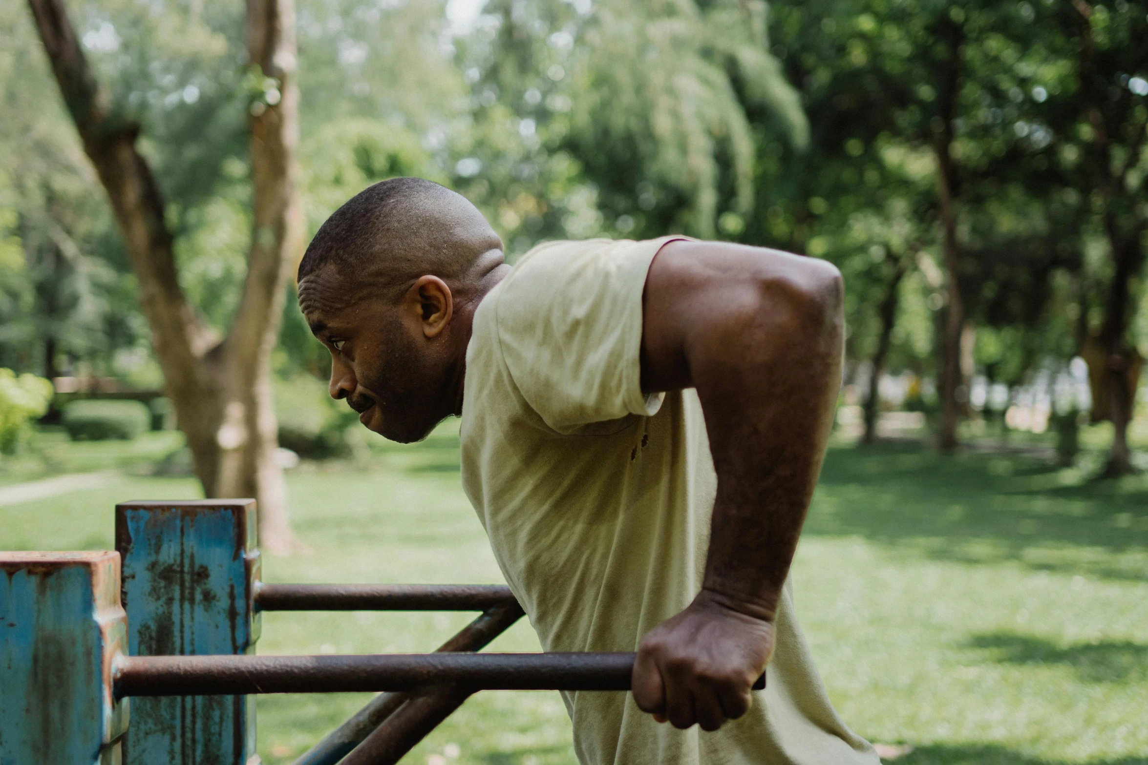 a man leaning against a rail in a park