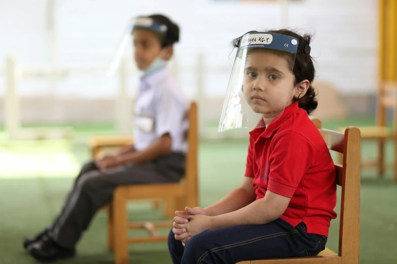 a child wearing plastic hats while sitting next to an adult