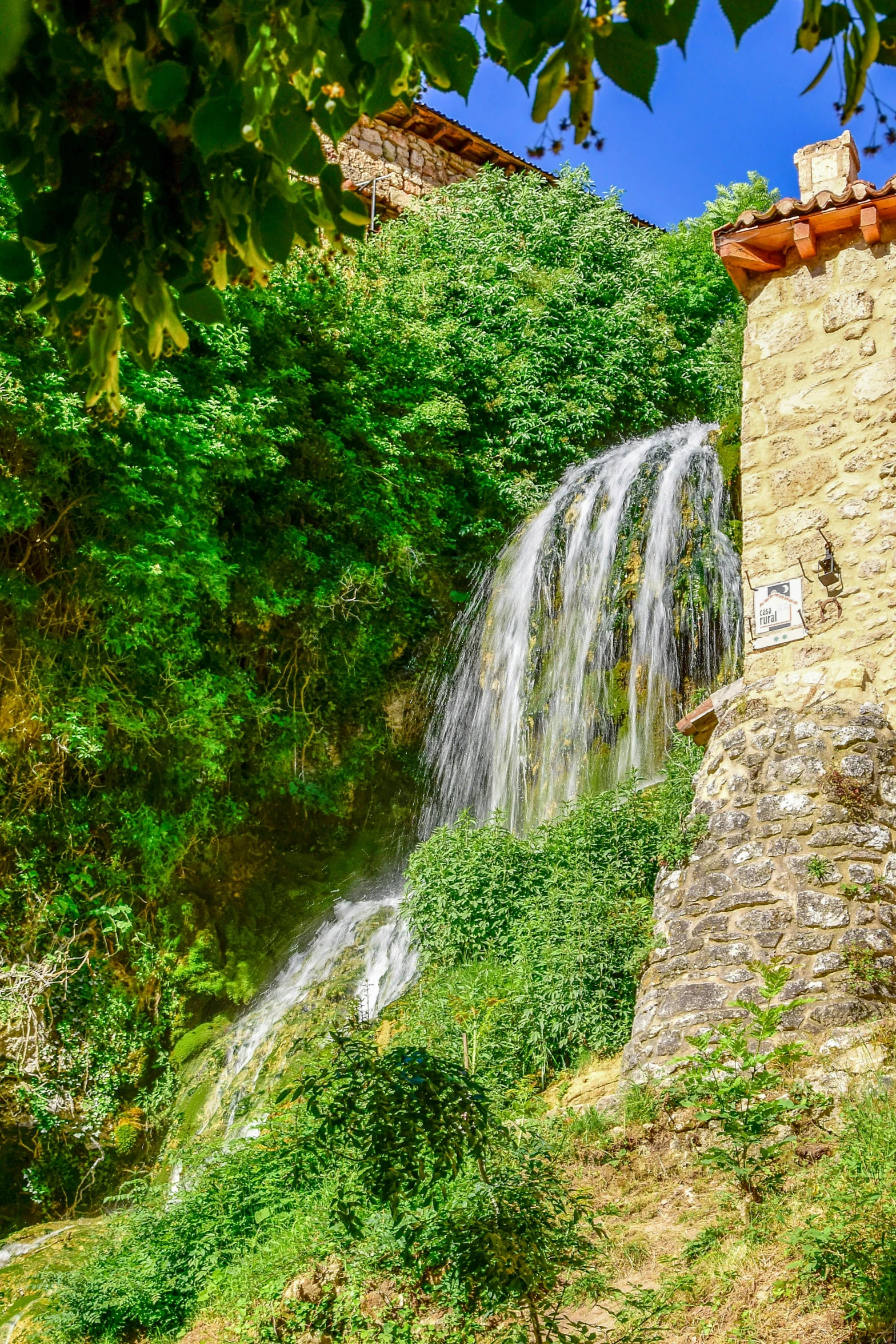 the waterfall is next to the green field