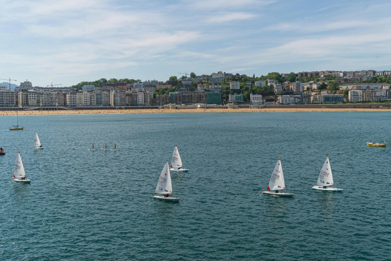 a group of boats on blue ocean next to shore