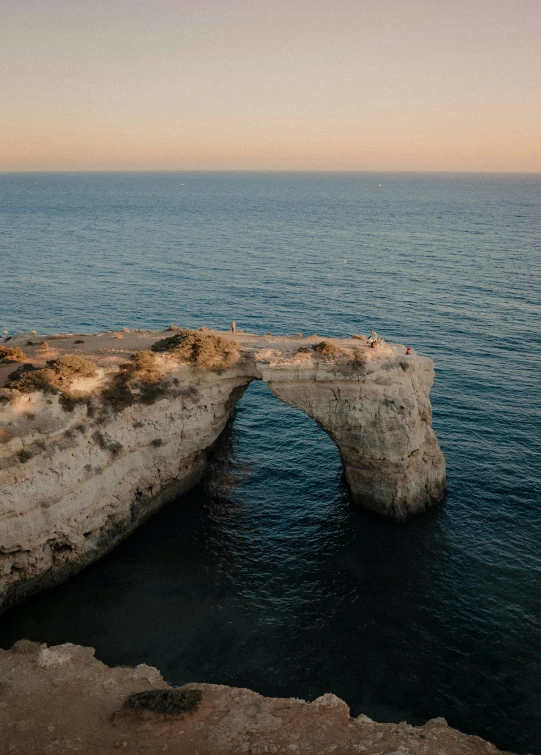 a rocky coastline near water with small rocks in the foreground