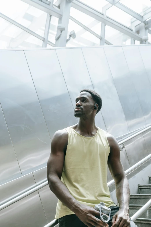 man in yellow shirt standing on escalator smiling