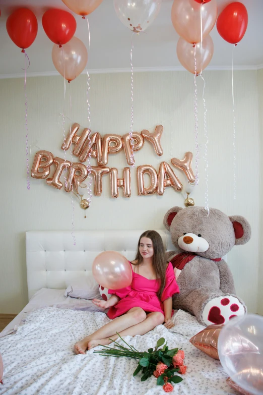 woman laying in bed smiling and surrounded by balloons and balloons