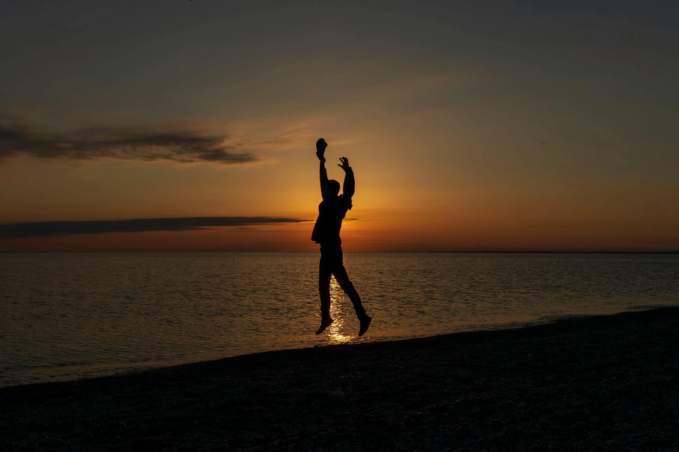 the person jumping in the air while standing at the beach